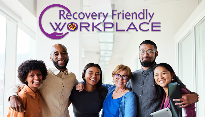recovery friendly workplace logo and 6 workers stand in  an office
